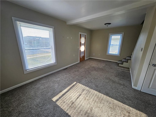 unfurnished room with carpet flooring, baseboards, beam ceiling, and stairway