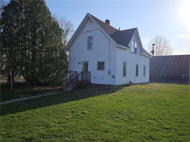 rear view of property with a lawn and a chimney