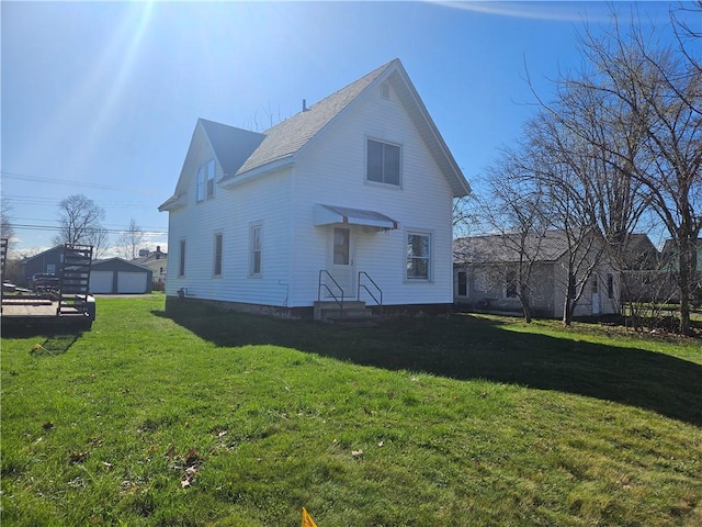 back of property with a lawn and a detached garage