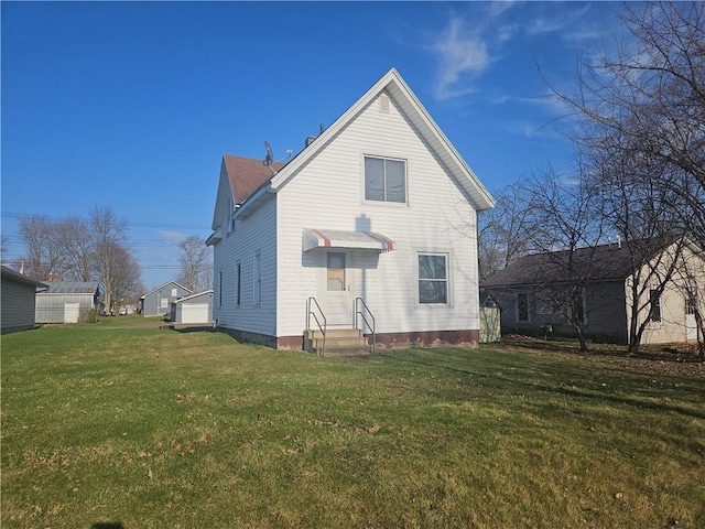 back of property featuring a lawn and entry steps