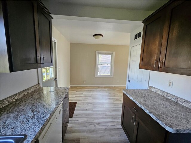 kitchen with baseboards, visible vents, dark brown cabinetry, and light wood-style flooring