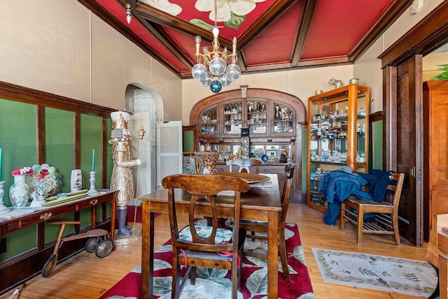 303 N Ashland Ave, Green Bay, WI 54303 - dining space featuring arched walkways, a notable chandelier, coffered ceiling, beamed ceiling, and wood finished floors