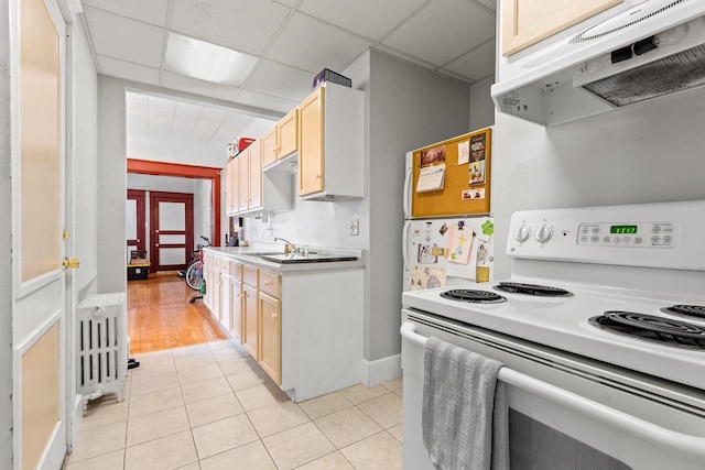 303 N Ashland Ave, Green Bay, WI 54303 - kitchen with white electric stove, a drop ceiling, light countertops, under cabinet range hood, and light tile patterned floors