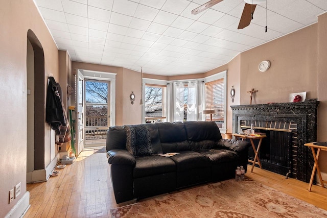 303 N Ashland Ave, Green Bay, WI 54303 - living room featuring a fireplace, hardwood / wood-style floors, arched walkways, and a ceiling fan