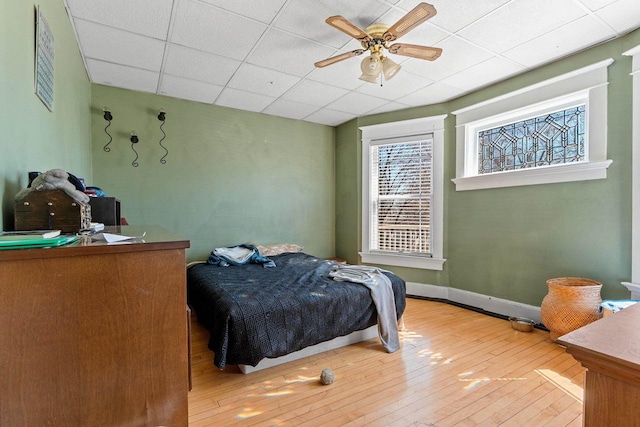 303 N Ashland Ave, Green Bay, WI 54303 - bedroom featuring baseboards, a drop ceiling, ceiling fan, and wood-type flooring