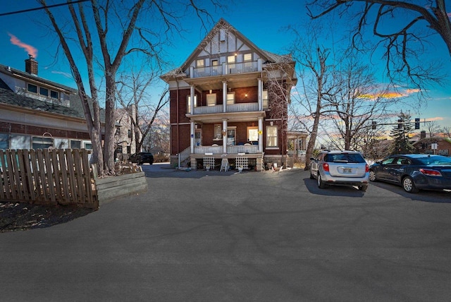 303 N Ashland Ave, Green Bay, WI 54303 - view of front of property featuring a porch, fence, a balcony, and brick siding