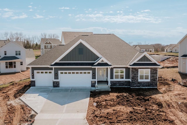 craftsman house featuring roof with shingles, stone siding, a garage, board and batten siding, and concrete driveway
