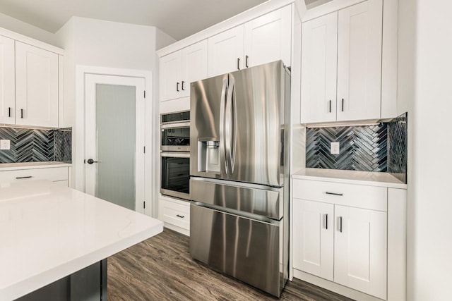 kitchen with white cabinetry, dark wood-style flooring, tasteful backsplash, and stainless steel appliances