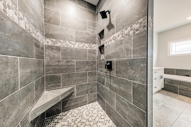 bathroom with a garden tub, a tile shower, and vanity