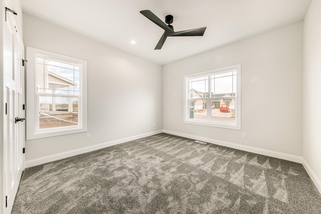 carpeted spare room with baseboards, a ceiling fan, recessed lighting, and a wealth of natural light