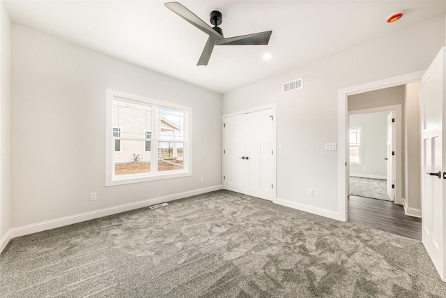 unfurnished bedroom with baseboards, ceiling fan, carpet flooring, and visible vents