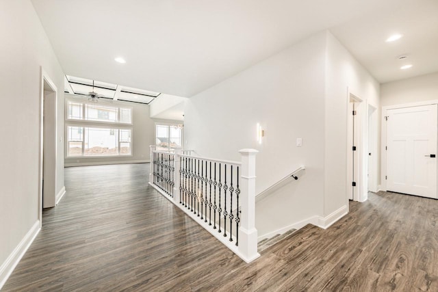 corridor featuring recessed lighting, baseboards, an upstairs landing, and wood finished floors