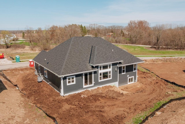 rear view of house featuring a shingled roof