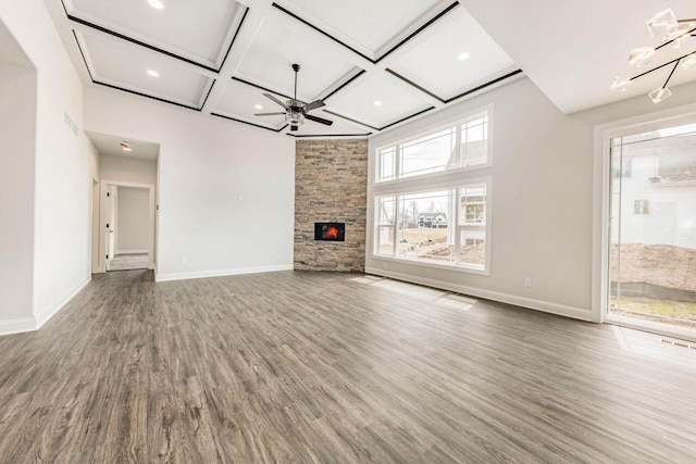 unfurnished living room featuring baseboards, ceiling fan, coffered ceiling, and wood finished floors