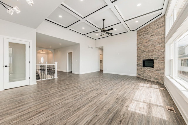 unfurnished living room with a notable chandelier, a fireplace, wood finished floors, visible vents, and coffered ceiling