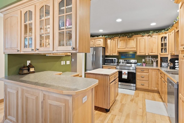 kitchen with appliances with stainless steel finishes, light wood-style floors, and light brown cabinetry