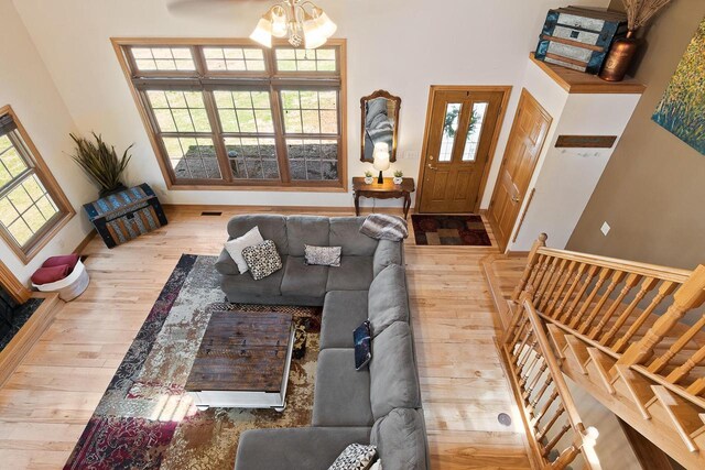 living area with baseboards, stairs, a towering ceiling, and hardwood / wood-style flooring
