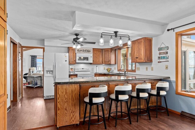 1096 Lakeshore Dr, Menasha, WI 54952 - kitchen featuring brown cabinets, dark wood-style floors, a sink, and white appliances