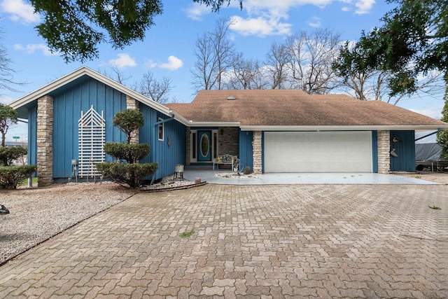 1096 Lakeshore Dr, Menasha, WI 54952 - ranch-style home featuring board and batten siding, an attached garage, decorative driveway, and roof with shingles