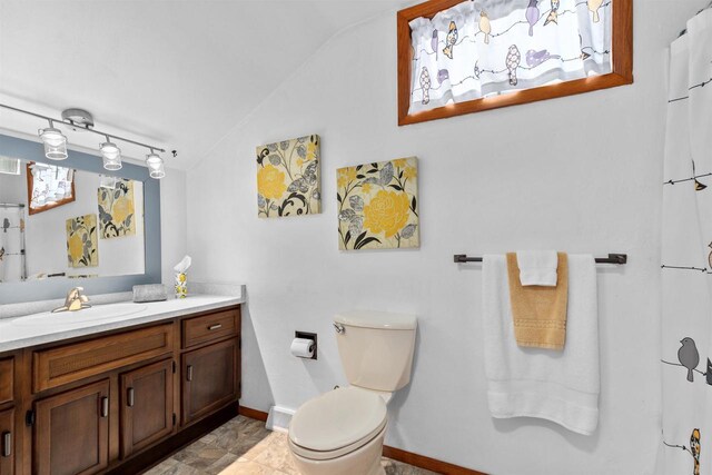 1096 Lakeshore Dr, Menasha, WI 54952 - bathroom featuring lofted ceiling, baseboards, vanity, and toilet