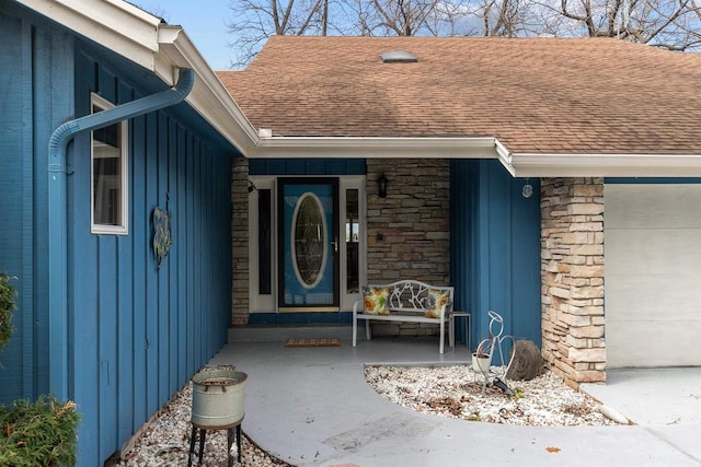 1096 Lakeshore Dr, Menasha, WI 54952 - view of exterior entry with a porch, stone siding, board and batten siding, and a shingled roof