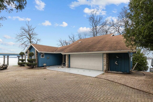 1096 Lakeshore Dr, Menasha, WI 54952 - ranch-style home featuring decorative driveway, board and batten siding, a shingled roof, and a garage