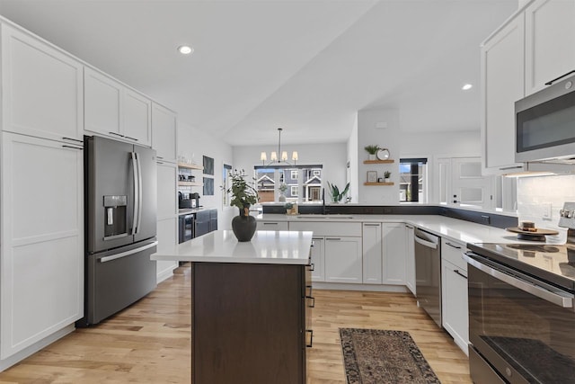 kitchen featuring an inviting chandelier, light wood-type flooring, white cabinets, a sink, and stainless steel appliances