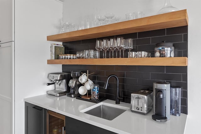 bar featuring a sink, a bar, and backsplash