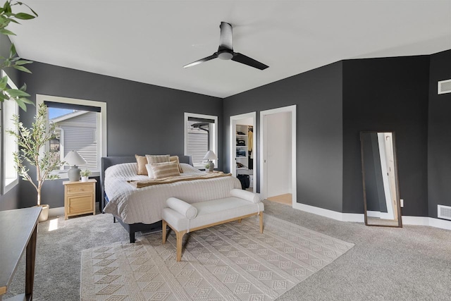 bedroom with visible vents, light carpet, baseboards, a spacious closet, and a ceiling fan