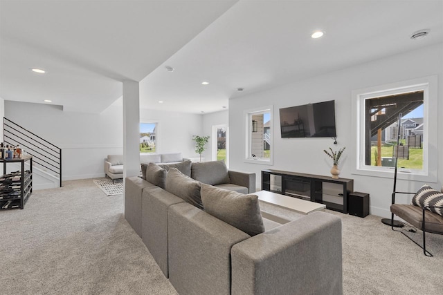 carpeted living area featuring recessed lighting, baseboards, plenty of natural light, and stairs