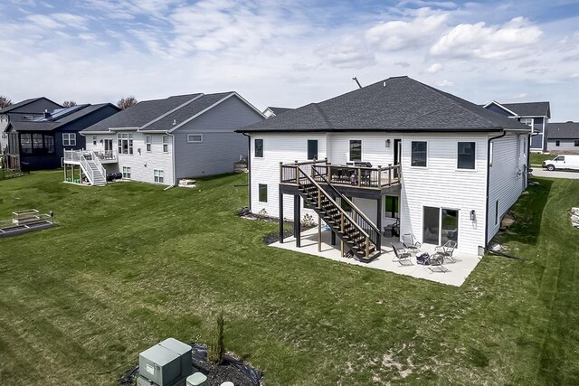 rear view of property with a patio, a deck, a yard, and stairs