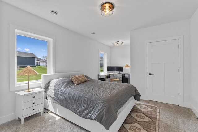 bedroom with baseboards and light colored carpet