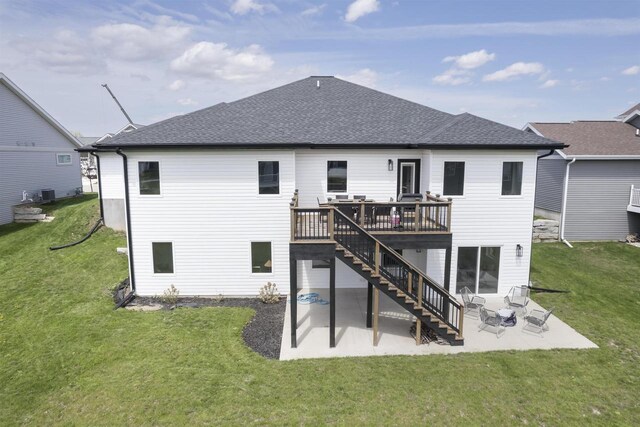 rear view of house with roof with shingles, stairs, a wooden deck, a patio, and a yard
