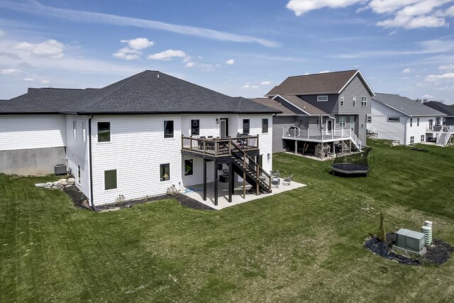 back of house with a residential view, stairs, a wooden deck, a patio area, and a lawn