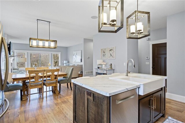 3426 Creek Ridge Dr, Eau Claire, WI 54703 - kitchen featuring stainless steel appliances, dark brown cabinets, visible vents, a sink, and light wood-style floors