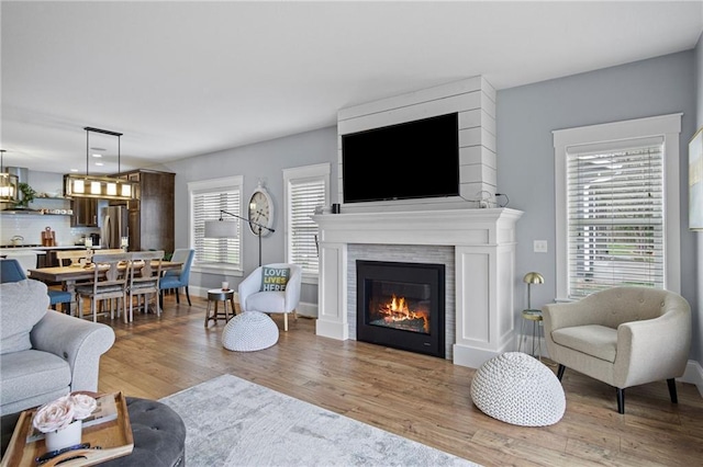 3426 Creek Ridge Dr, Eau Claire, WI 54703 - living room featuring a glass covered fireplace, a healthy amount of sunlight, and light wood finished floors