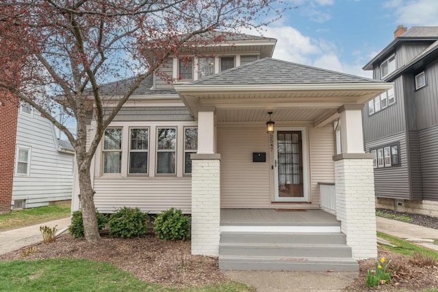 bungalow featuring a shingled roof and covered porch