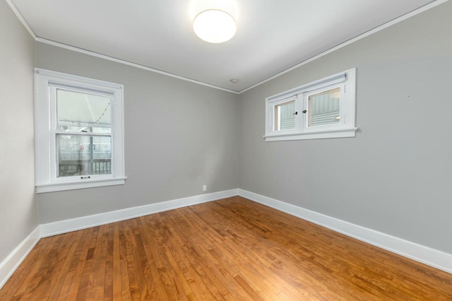 unfurnished room with baseboards, a healthy amount of sunlight, and crown molding
