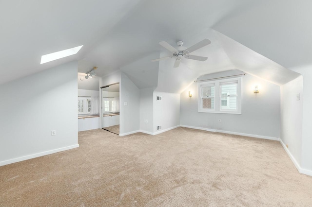 additional living space with a healthy amount of sunlight, carpet floors, and vaulted ceiling with skylight