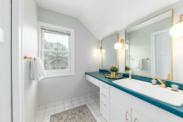 bathroom featuring tile patterned floors, vaulted ceiling, and vanity