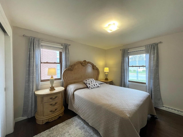 1139 Roscoe St, Green Bay, WI 54304 - bedroom with a baseboard heating unit, baseboards, dark wood-style floors, and multiple windows