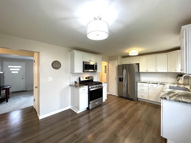 1139 Roscoe St, Green Bay, WI 54304 - kitchen with stainless steel appliances, dark wood-style floors, a sink, tasteful backsplash, and white cabinetry
