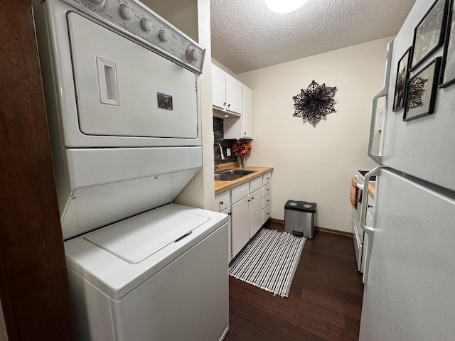 4 Hawthorn Trl, Wisconsin Dells, WI 53965 - laundry area featuring a textured ceiling, stacked washer / dryer, dark wood finished floors, cabinet space, and a sink