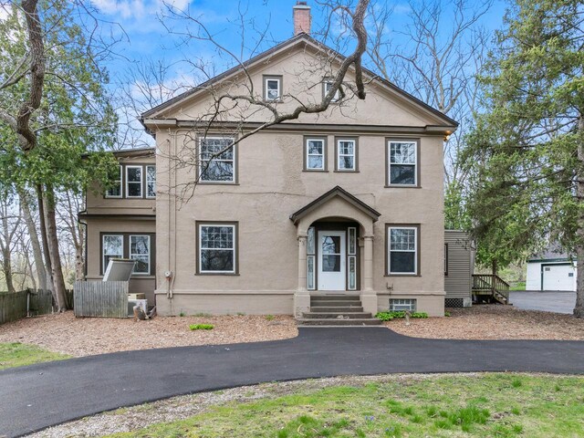 28094 E State Rd, Island Lake, IL 60042 - view of front of house with a chimney, stucco siding, and fence