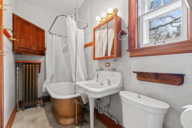 28094 E State Rd, Island Lake, IL 60042 - bathroom featuring radiator heating unit, curtained shower, a soaking tub, baseboards, and toilet