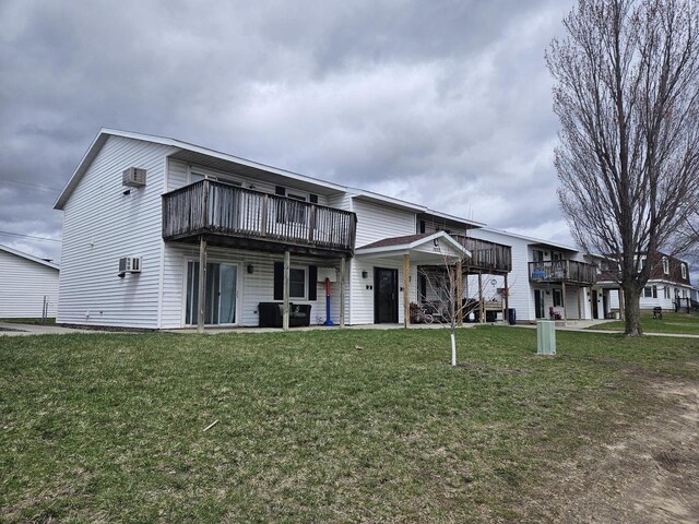view of front facade featuring a front lawn, a wall mounted air conditioner, and a deck