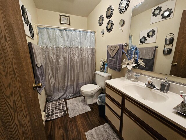 full bath featuring toilet, a shower with shower curtain, vanity, and wood finished floors