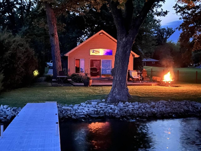 rear view of house featuring a lawn, an outdoor fire pit, and a deck