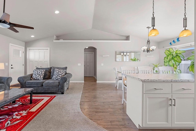 830 Roth Rd, De Pere, WI 54115 - living room with arched walkways, lofted ceiling, wood finished floors, and ceiling fan with notable chandelier