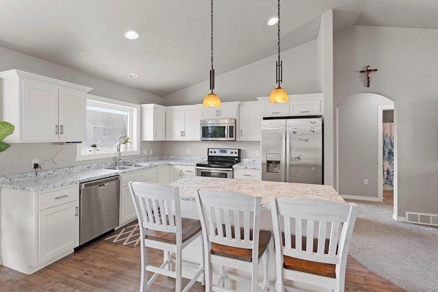 830 Roth Rd, De Pere, WI 54115 - kitchen with a sink, vaulted ceiling, visible vents, white cabinetry, and appliances with stainless steel finishes